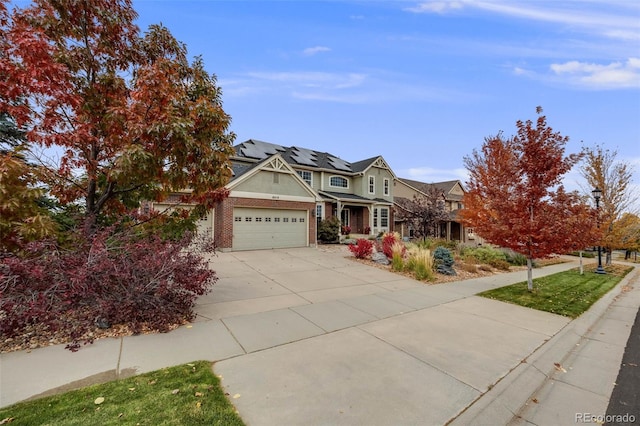 view of front of property with a garage, concrete driveway, brick siding, and roof mounted solar panels