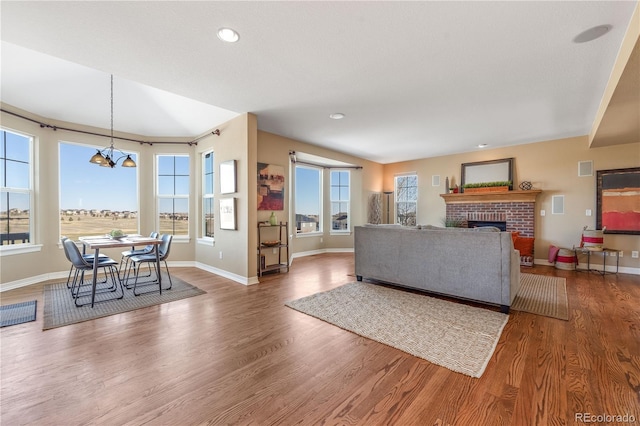 living area with a healthy amount of sunlight, a fireplace, and wood finished floors