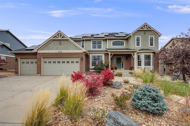 view of front of house featuring a garage, solar panels, concrete driveway, and brick siding