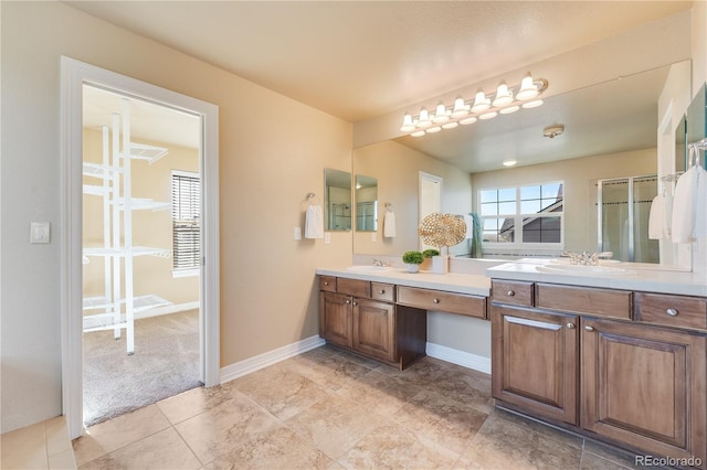 full bathroom featuring double vanity, an enclosed shower, a sink, and baseboards