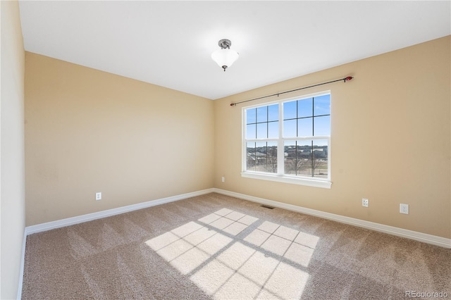 carpeted empty room featuring visible vents and baseboards