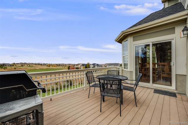 deck with outdoor dining space and a grill