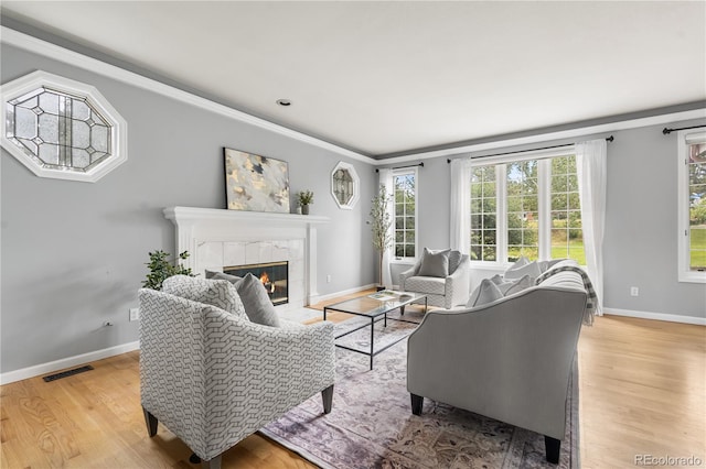 18963 E Long Ave, Centennial, CO 80016 - living room with healthy amount of natural light, light wood-type flooring, a tiled fireplace, and ornamental molding