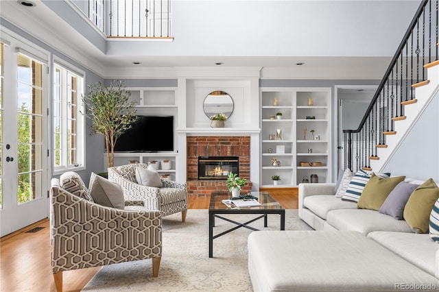 18963 E Long Ave, Centennial, CO 80016 - living room featuring wood finished floors, stairs, ornamental molding, a fireplace, and a high ceiling