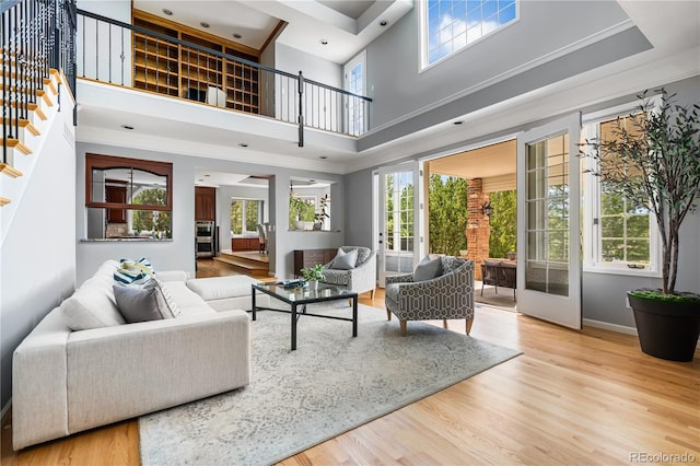 18963 E Long Ave, Centennial, CO 80016 - living area featuring stairs, a towering ceiling, light wood-style floors, and crown molding