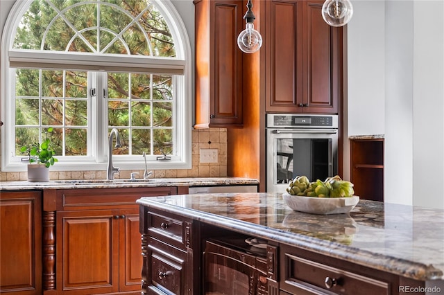 18963 E Long Ave, Centennial, CO 80016 - kitchen featuring oven, light stone countertops, pendant lighting, and tasteful backsplash