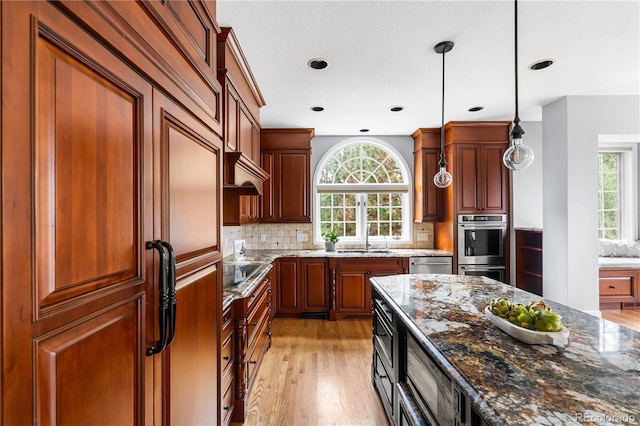 18963 E Long Ave, Centennial, CO 80016 - kitchen with stainless steel appliances, stone countertops, decorative light fixtures, tasteful backsplash, and light wood-style floors