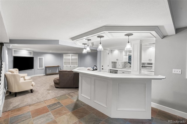 18963 E Long Ave, Centennial, CO 80016 - kitchen featuring stone finish flooring, white cabinetry, a textured ceiling, light countertops, and pendant lighting