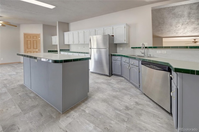 kitchen with decorative backsplash, a textured ceiling, stainless steel appliances, sink, and white cabinetry