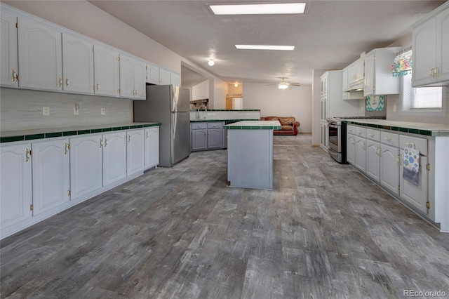 kitchen with stainless steel appliances, a kitchen island, and white cabinetry