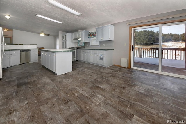 kitchen with stove, white cabinets, a textured ceiling, dishwasher, and a center island