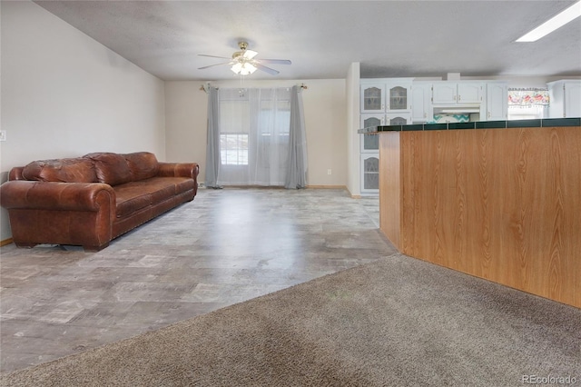 unfurnished living room with ceiling fan and a textured ceiling