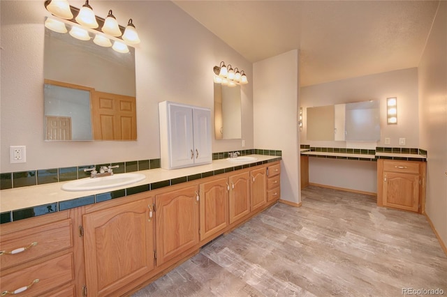 bathroom with vanity, vaulted ceiling, and hardwood / wood-style flooring