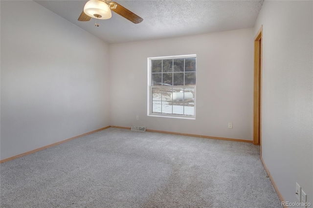 empty room featuring ceiling fan, carpet floors, and a textured ceiling