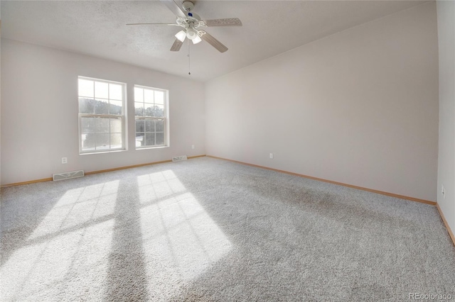 carpeted empty room with ceiling fan and a textured ceiling