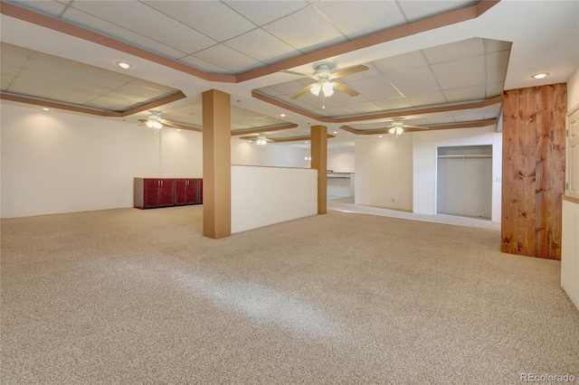 basement featuring a drop ceiling and light colored carpet