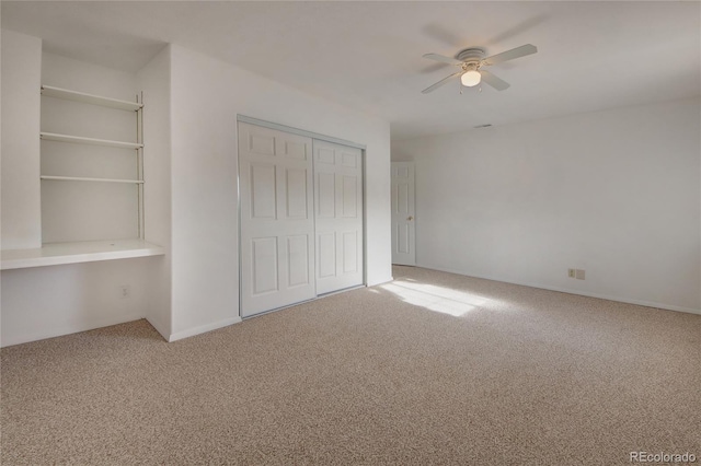 unfurnished bedroom featuring carpet flooring, ceiling fan, and a closet