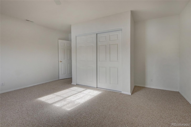 unfurnished bedroom featuring light carpet and a closet