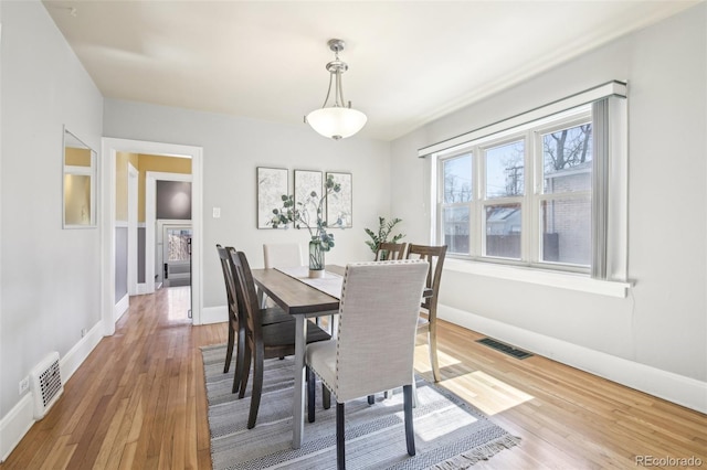 dining area featuring visible vents, light wood-type flooring, and baseboards