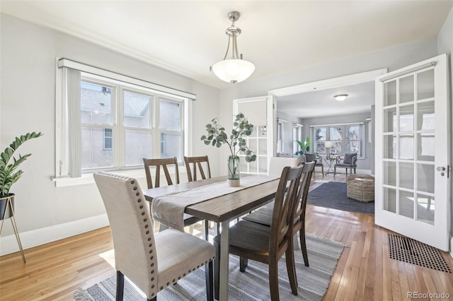 dining area with baseboards and light wood-style floors