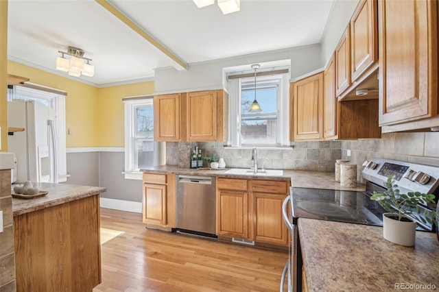 kitchen with plenty of natural light, backsplash, appliances with stainless steel finishes, and a sink