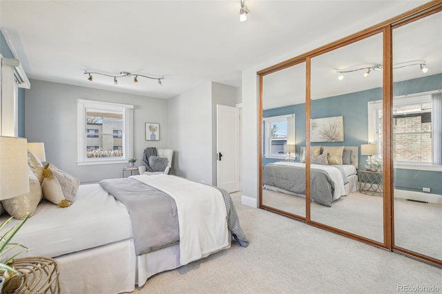 bedroom with light carpet, track lighting, and visible vents