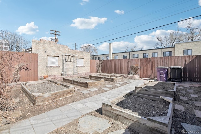 view of yard featuring an outdoor structure, a vegetable garden, and a fenced backyard