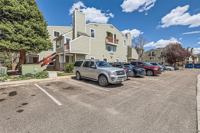 uncovered parking lot featuring stairway and a residential view