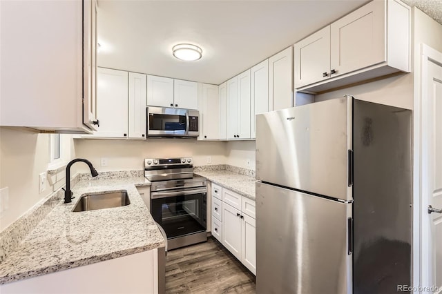 kitchen with a sink, appliances with stainless steel finishes, and white cabinetry