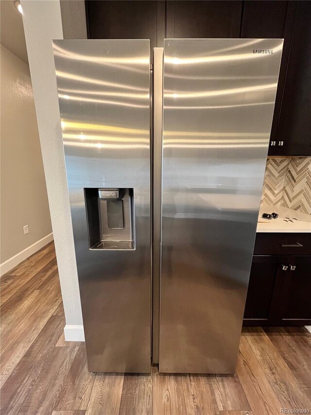 16841 Askins Loop Unit 208, Parker, CO 80134 - room details featuring baseboards, light wood-type flooring, stainless steel fridge, and tasteful backsplash