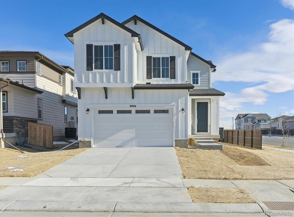 view of front of property with central AC unit and a garage