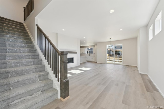 unfurnished living room featuring light hardwood / wood-style flooring and a notable chandelier