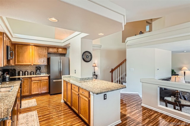 20336 E 48th Dr, Denver, CO 80249 - kitchen featuring stainless steel appliances, light stone countertops, light wood-type flooring, and open floor plan