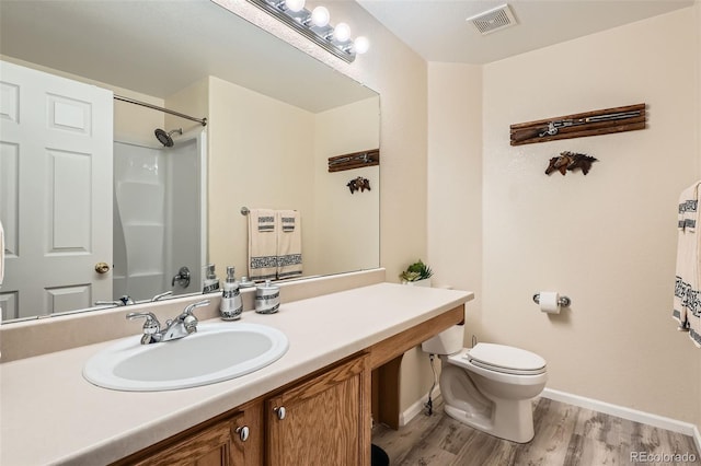 20336 E 48th Dr, Denver, CO 80249 - bathroom featuring wood finished floors, toilet, baseboards, vanity, and a shower