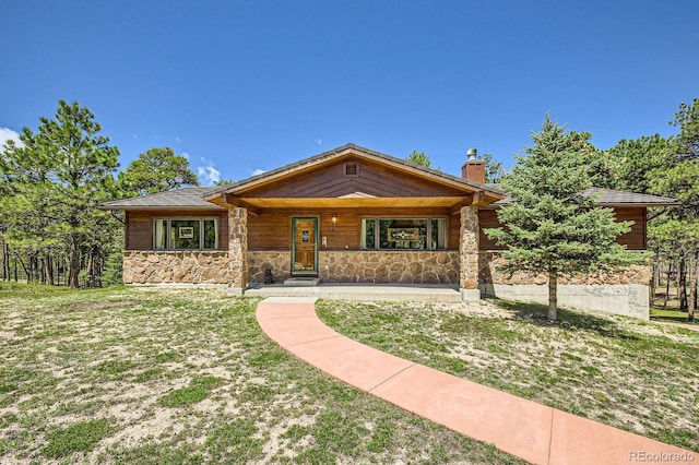 18150 Martingale Rd, Monument, CO 80132 - view of front of home with stone siding, a porch, a chimney, and a front lawn