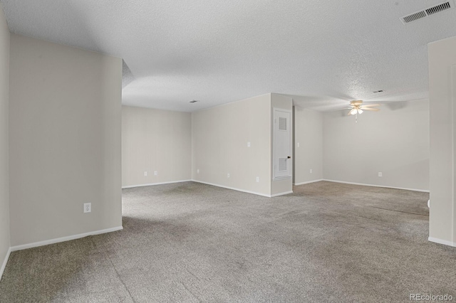 carpeted spare room featuring a textured ceiling and ceiling fan