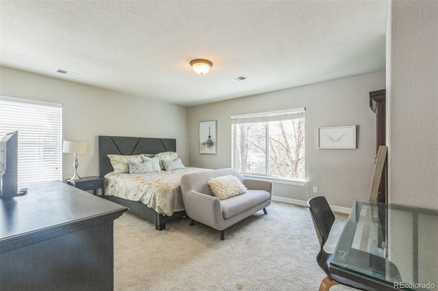 bedroom featuring a textured ceiling, visible vents, and carpet floors