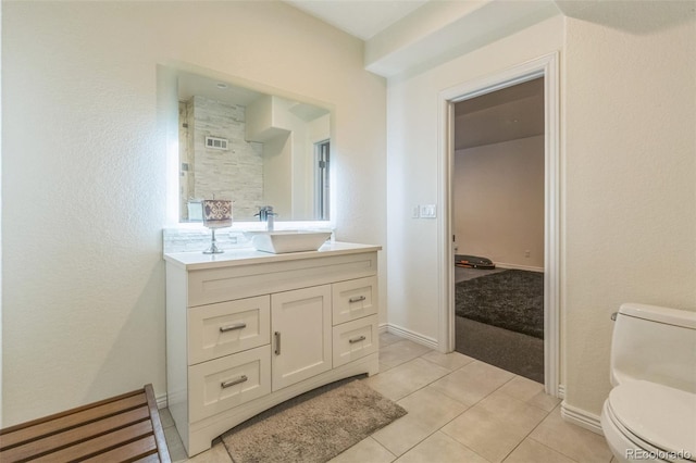 bathroom with toilet, baseboards, vanity, and tile patterned flooring