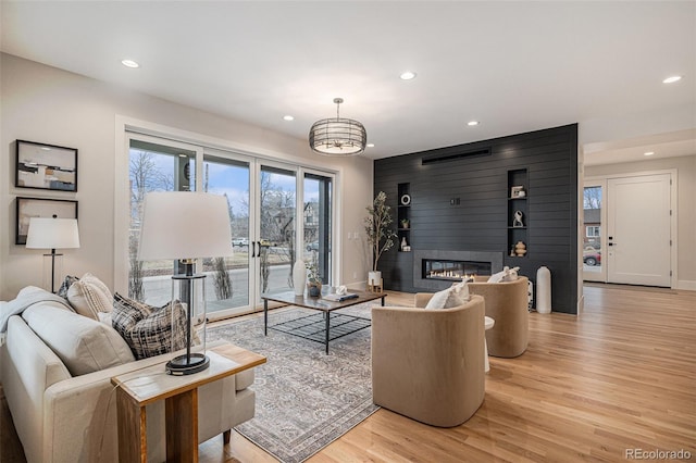 living room with a large fireplace and light hardwood / wood-style floors