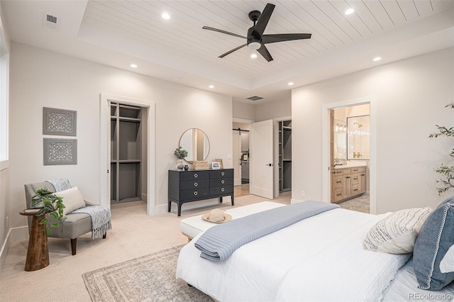 bedroom featuring a raised ceiling, a spacious closet, connected bathroom, wood ceiling, and a closet