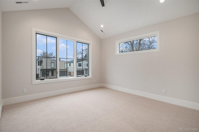 carpeted spare room with vaulted ceiling