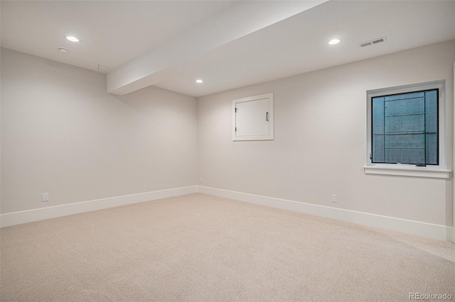 spare room featuring beamed ceiling and carpet floors