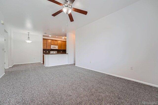 2705 S Danube Way Unit 110, Aurora, CO 80013 - unfurnished living room featuring track lighting, ceiling fan, carpet flooring, and baseboards