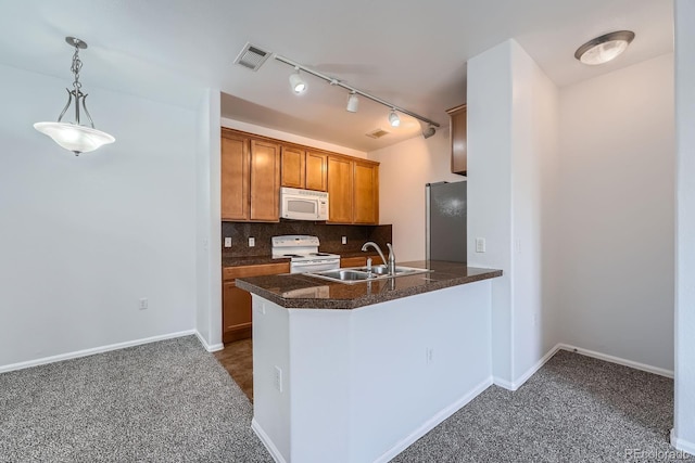 2705 S Danube Way Unit 110, Aurora, CO 80013 - kitchen with white appliances, dark carpet, a sink, and a peninsula