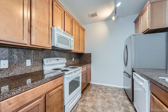2705 S Danube Way Unit 110, Aurora, CO 80013 - kitchen with white appliances, tasteful backsplash, baseboards, and rail lighting
