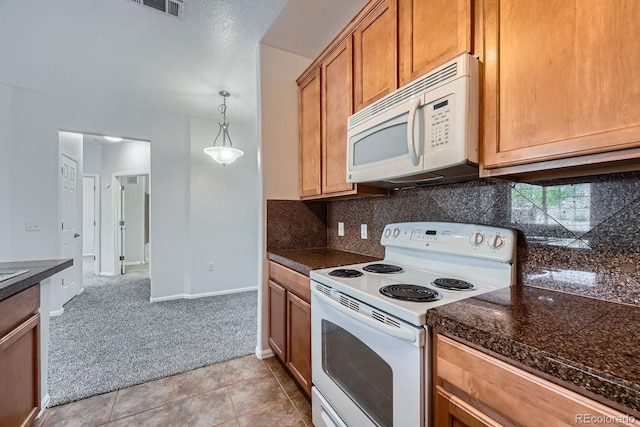2705 S Danube Way Unit 110, Aurora, CO 80013 - kitchen featuring white appliances, light carpet, tasteful backsplash, and light tile patterned floors