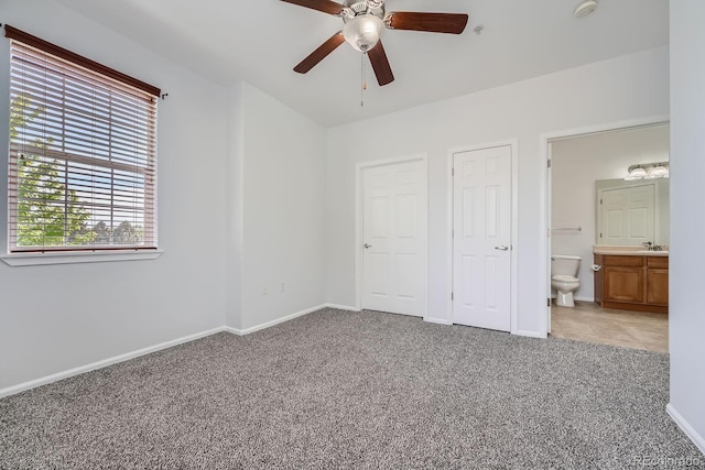 2705 S Danube Way Unit 110, Aurora, CO 80013 - unfurnished bedroom with carpet floors, baseboards, connected bathroom, and a ceiling fan