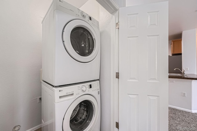 2705 S Danube Way Unit 110, Aurora, CO 80013 - laundry area featuring estacked washer and dryer, baseboards, and carpet floors