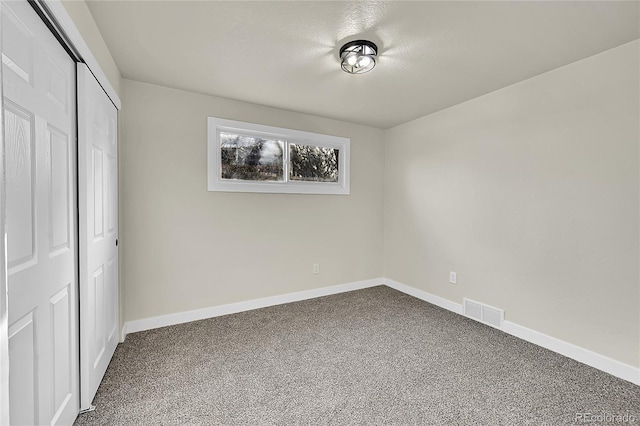 unfurnished bedroom featuring carpet flooring and a closet