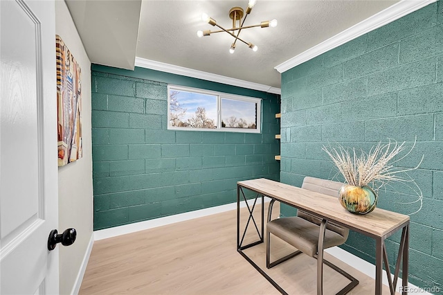 office area featuring hardwood / wood-style flooring, crown molding, brick wall, and an inviting chandelier